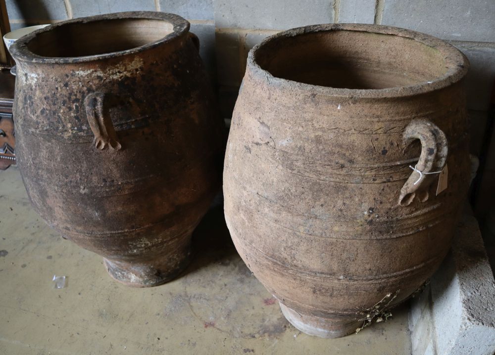 A pair of three-handled terracotta oil jars, each with ribbed sides and narrow foot, height 100cm (faults)